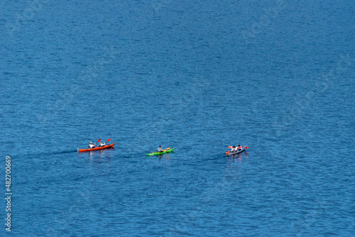 personas en bote remando en un lago de agua color azul