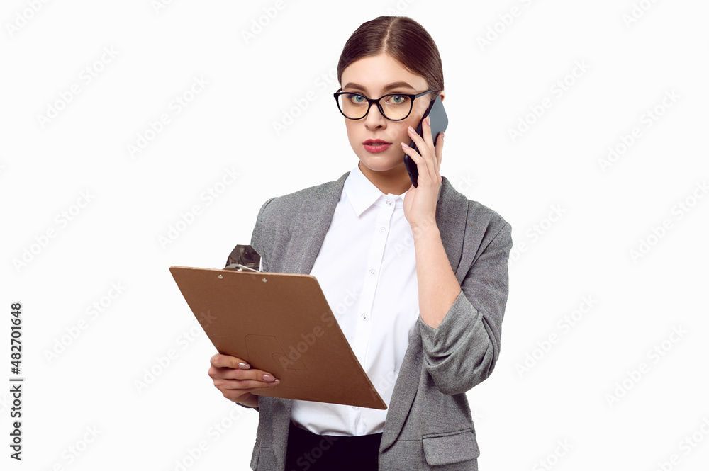 Young successful business woman in a jacket white shirts talking on the phone and holding a folder with documents tablet on a white isolated background Young successful business woman in a jacket white shirts talking on the phone and holding a folder with documents tablet on a white isolated background
