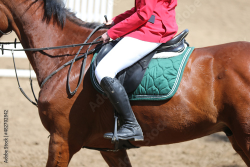 Unknown dressage rider sits on her sport horse during race © acceptfoto