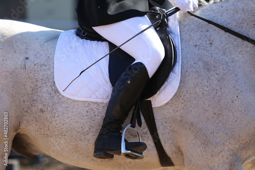 Unknown dressage rider sits on her sport horse during race