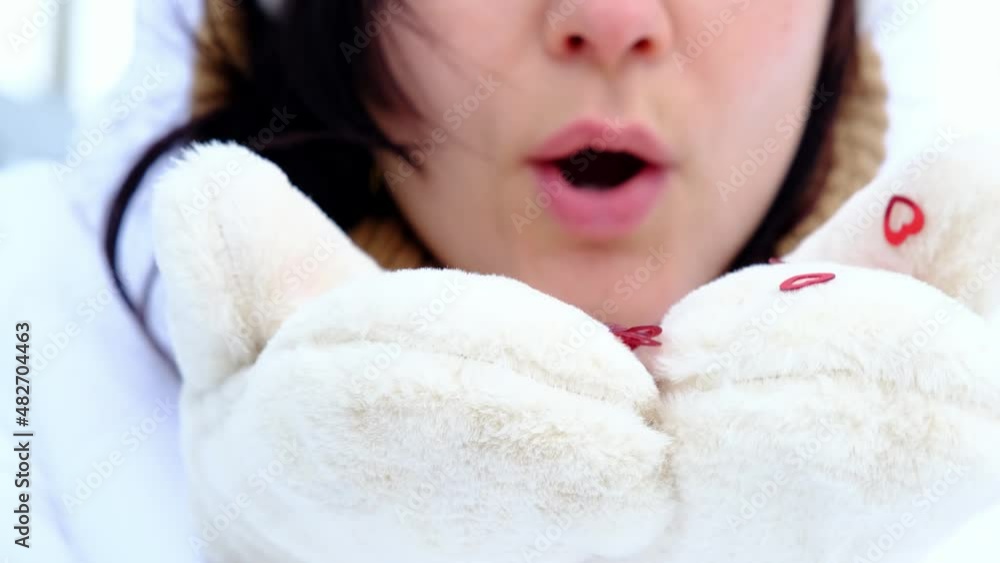 A woman blows red sequins in the shape of hearts from warm fur mittens. Slow-motion video, close-up. Valentine's Day, love, feelings A woman blows red sequins in the shape of hearts from warm fur mittens. Slow-motion video, close-up. Valentine's Day, love, feelings