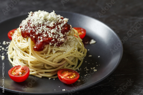 Spaghetti pasta cooked with tomato sauce and parmesan, an Italian dish.
