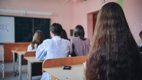 Pupils of the 11th grade in the class at the desks during the lesson. Russian school.