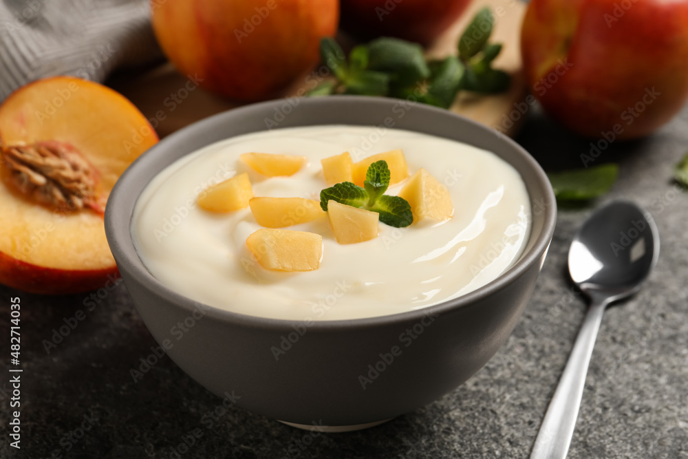 Delicious yogurt with fresh peach and mint on grey table, closeup Delicious yogurt with fresh peach and mint on grey table, closeup