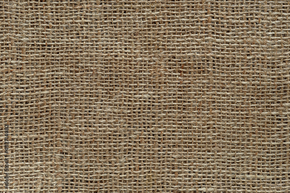 Burlap fabric texture macro. Background of coarsely woven sackcloth from jute, hemp or flax. Design element for rustic country style. Brown tan сanvas cloth as craft material. Burlap fabric texture macro. Background of coarsely woven sackcloth from jute, hemp or flax. Design element for rustic country style. Brown tan сanvas cloth as craft material.