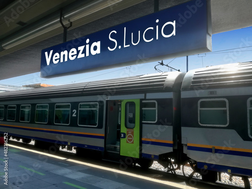 Obraz na plátně Venice Santa Lucia railway station sign with a stationary train in the background