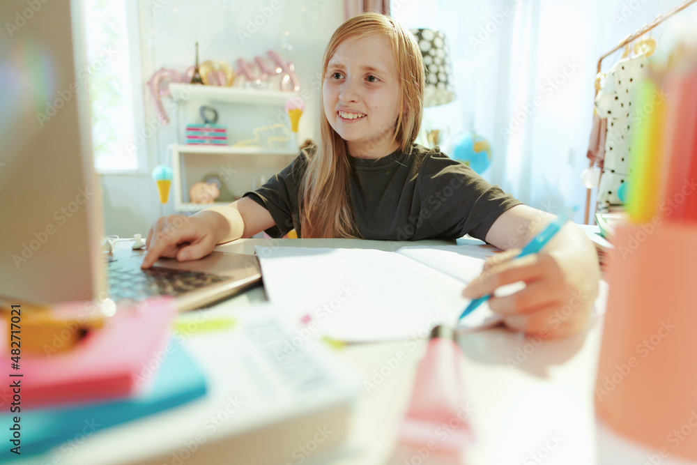 smiling girl having distance education at home in sunny day smiling girl having distance education at home in sunny day
