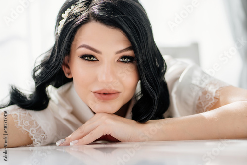 the face of a beautiful brunette bride with long hair and a white hairpin. 