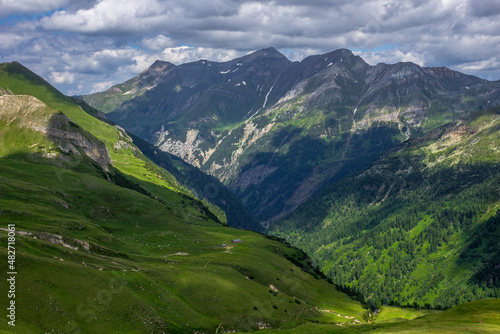 Austrian Alps. Mount Grossglockner. Highlands in summer. High mountains in the shadow of clouds and the rays of the sun. Mountain landscape. Juicy greens. Cloudy sky.