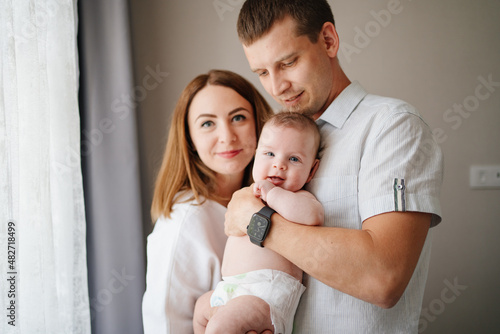 a happy family with a newborn baby. mom, dad and baby. © andrey