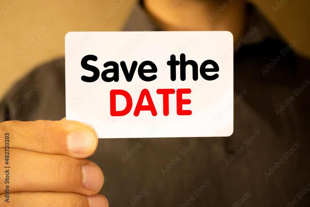 Business and people concept. On a gray background, a business card with the inscription - Save the date Business and people concept. On a gray background, a business card with the inscription - Save the date