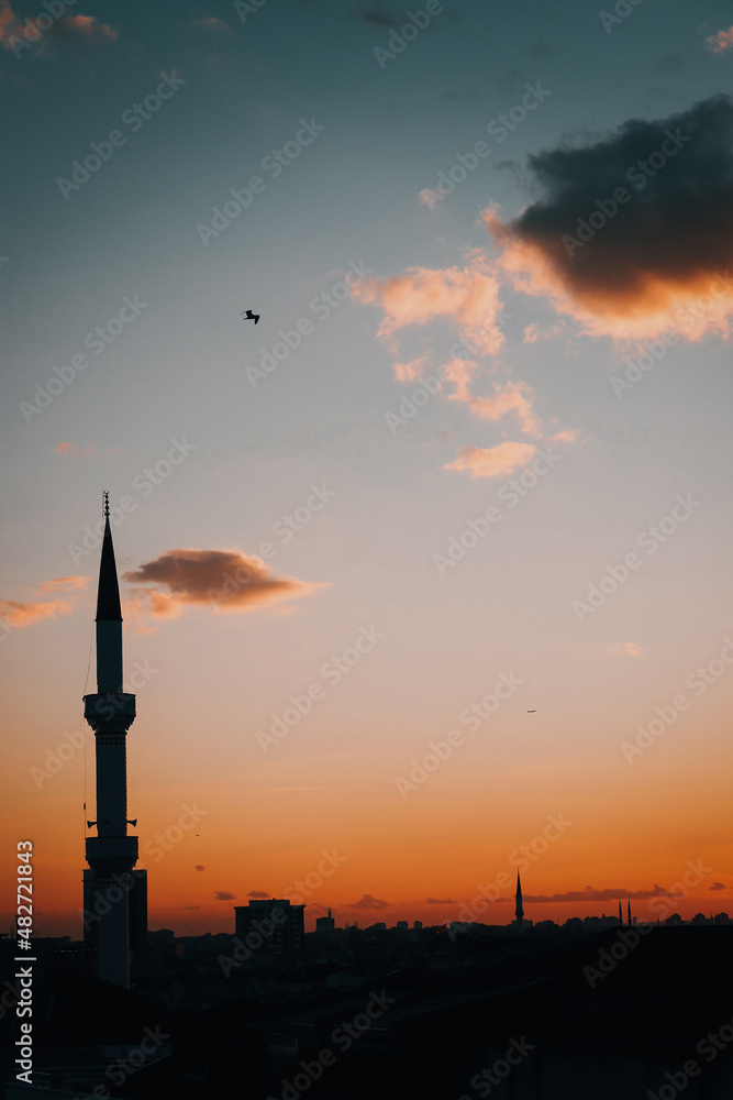 Minaret and city skyline at colorful sunset