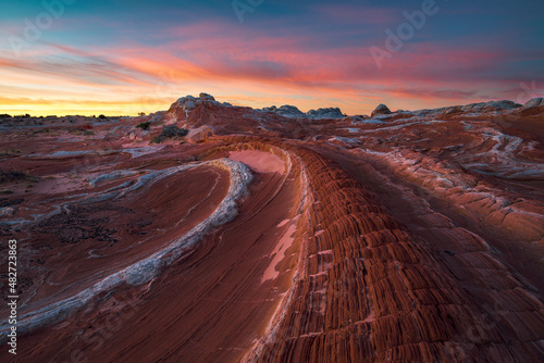 A colorful sunrise in the northern Arizona red rock desert fills the landscape with rich reds and purples, USA.