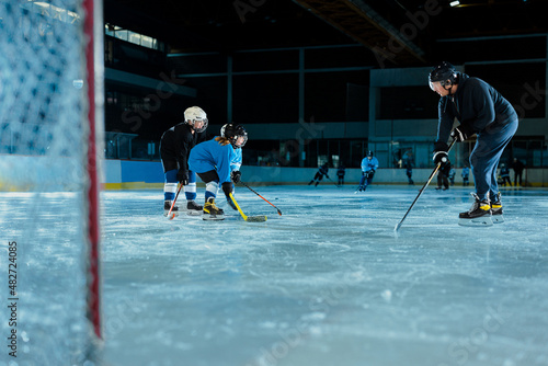 Ice hockey players play ice hockey with trainer