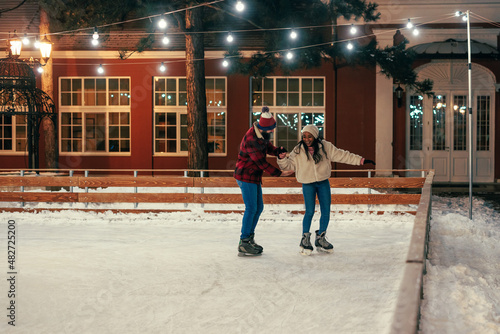 Biracial couple having date at outdoors rink