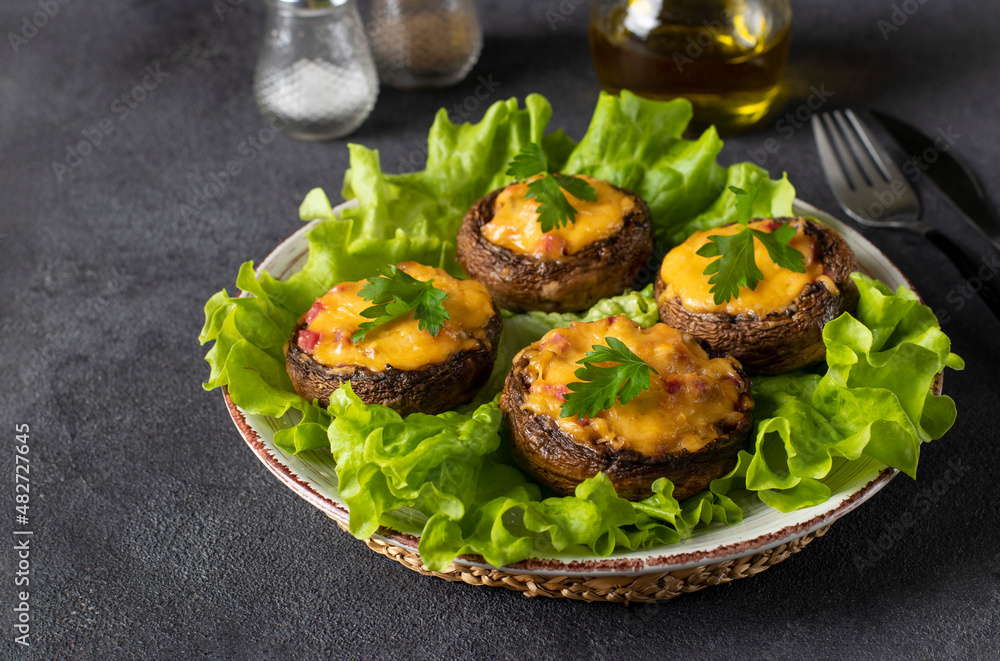 Baked champignons with sausage and cheese on gray background, hot appetizer