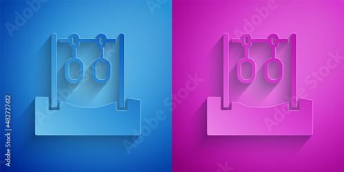 Paper cut Gymnastic rings icon isolated on blue and purple background. Playground equipment with hanging rope with rings. Paper art style. Vector