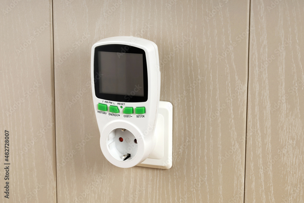 Wattmeter for measuring electricity costs in devices connected to outlet, saving, expense analysis, in socket on wall Wattmeter for measuring electricity costs in devices connected to outlet, saving, expense analysis, in socket on wall