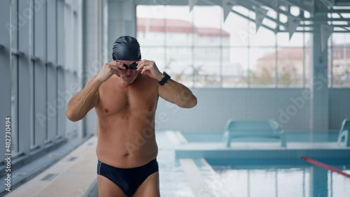 Active senior man preparing to swim in swimming pool. photo