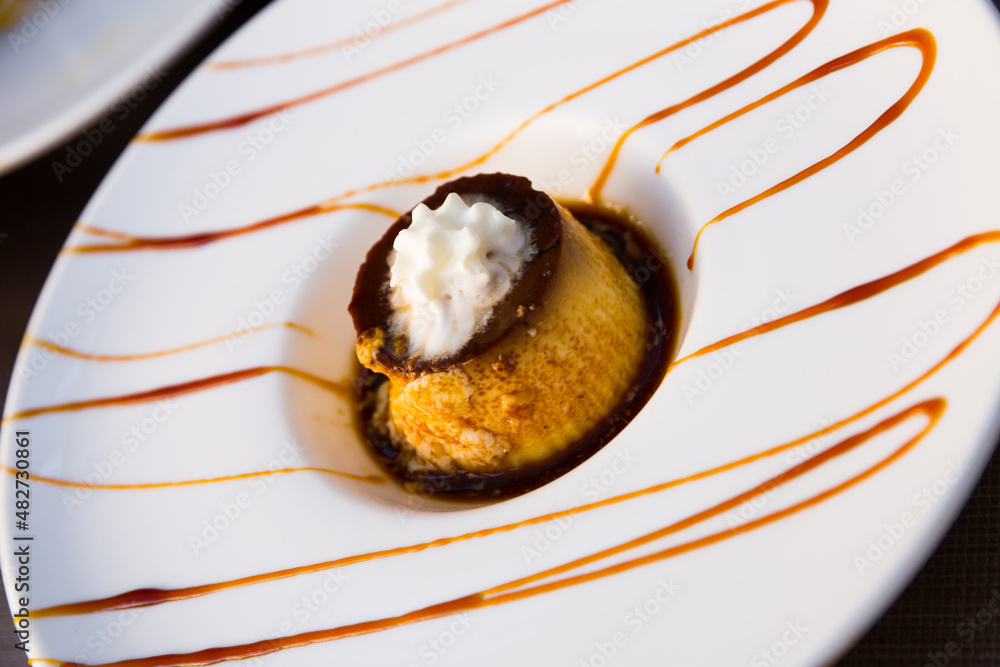 Fototapeta premium Popular Spanish custard dessert flan with layer of caramel sauce and whipped cream