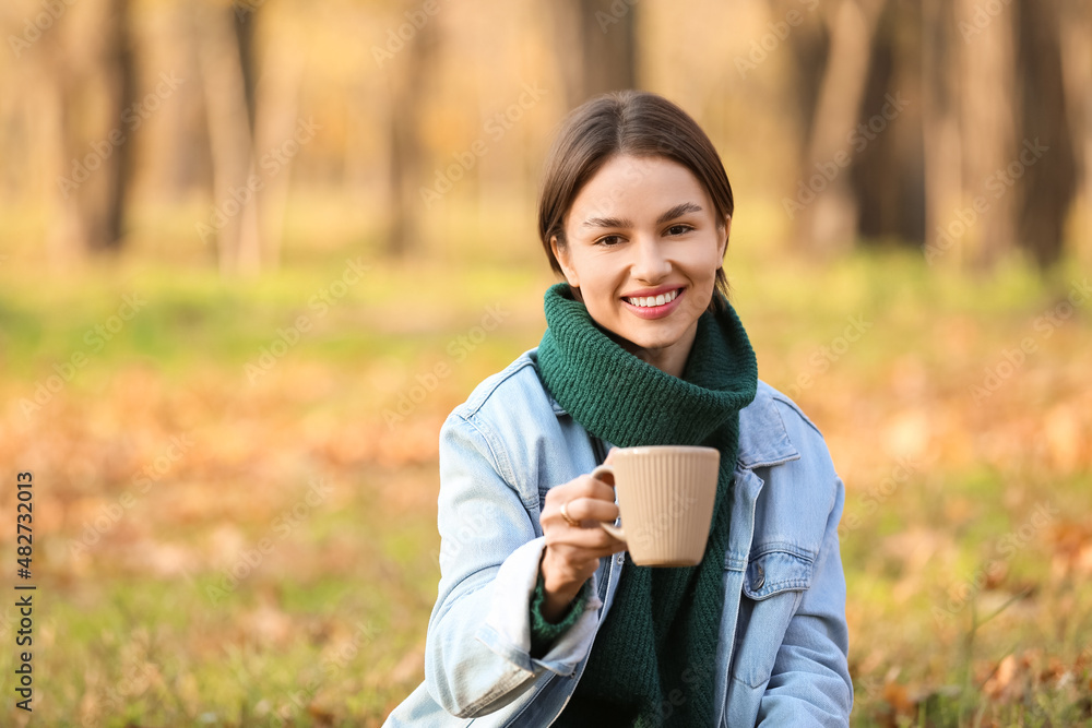 Beautiful smiling woman with cup of tasty tea in autumn park Beautiful smiling woman with cup of tasty tea in autumn park