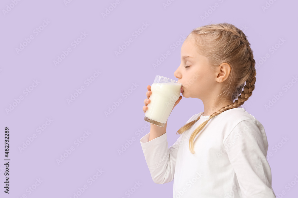 Cute little girl drinking milk on lilac background Cute little girl drinking milk on lilac background