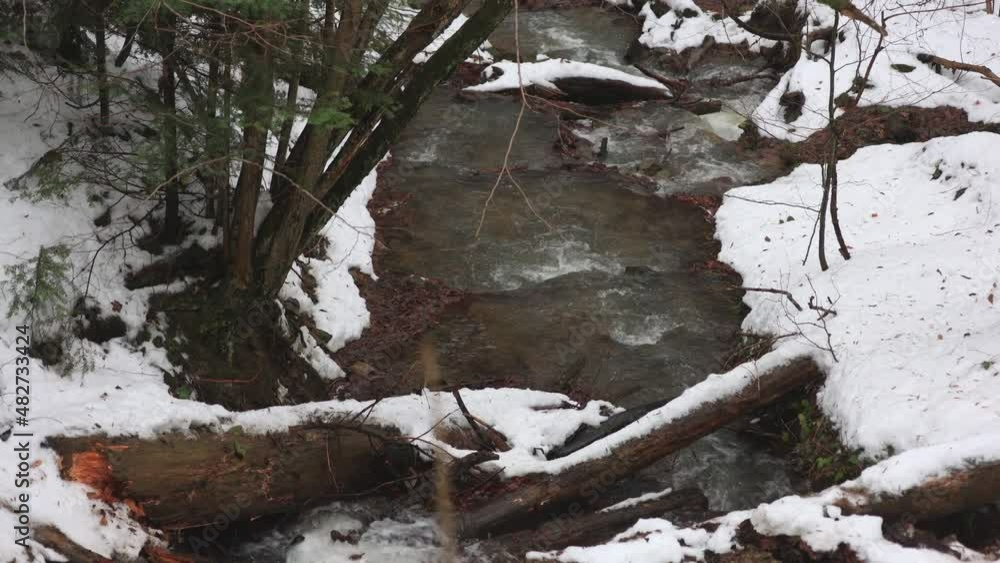 Small mountain river in winter. Forest covered in snow. Small mountain river in winter. Forest covered in snow.