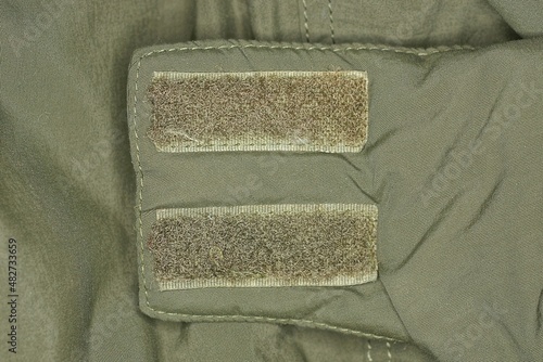 two plastic velcro fasteners on the green fabric of the collar on the jacket photo