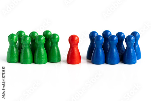 Eine rote Spielfigur in Mitte, zwischen zwei Gruppen von anderen Spielfiguren in blauer und grün