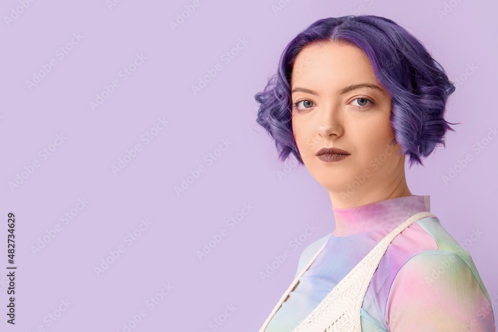 Beautiful young woman with violet hair on color background. Very Peri - color of year 2022 Beautiful young woman with violet hair on color background. Very Peri - color of year 2022