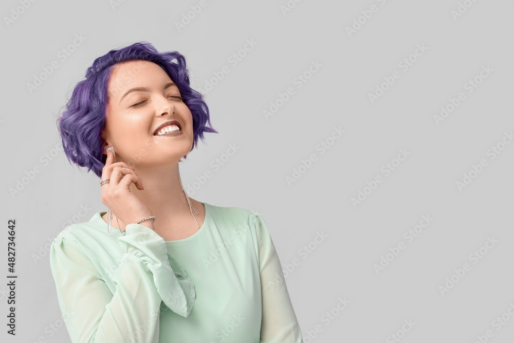 Beautiful young woman with violet hair on light background. Very Peri - color of year 2022 Beautiful young woman with violet hair on light background. Very Peri - color of year 2022