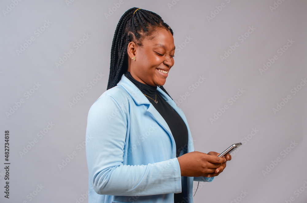 beautiful african lady isolated over white background smiling as she operates her phone beautiful african lady isolated over white background smiling as she operates her phone