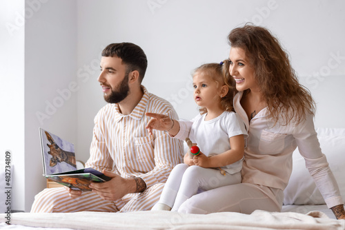 Happy young family in bedro...