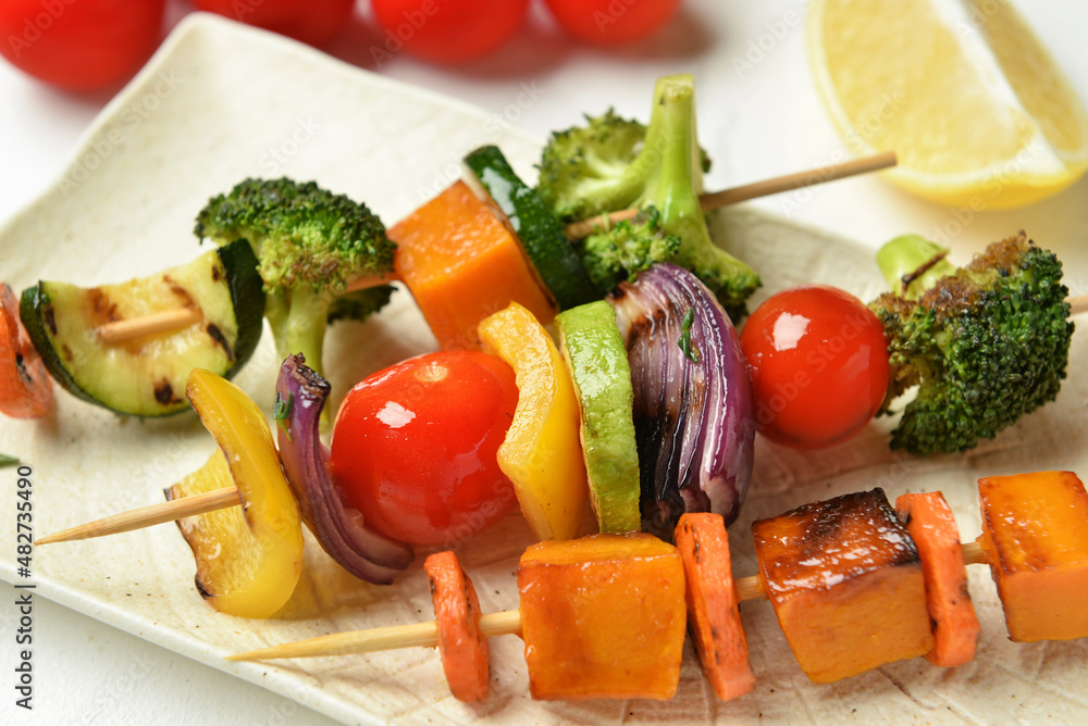 Plate with tasty vegetable skewers on table, closeup Plate with tasty vegetable skewers on table, closeup