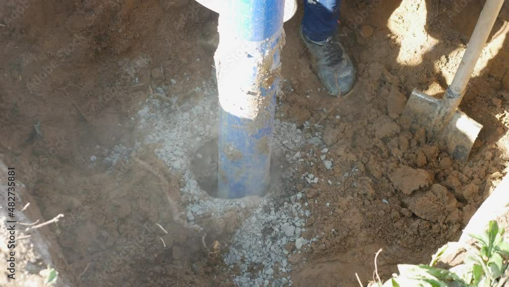 Installing a well, pouring crushed stone into a hole, an industrial