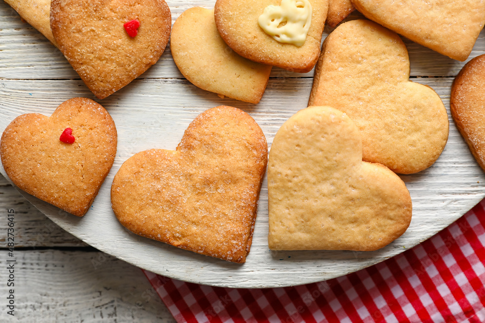 Board with tasty heart shaped cookies on white wooden background, closeup. Valentines Day celebration Board with tasty heart shaped cookies on white wooden background, closeup. Valentines Day celebration