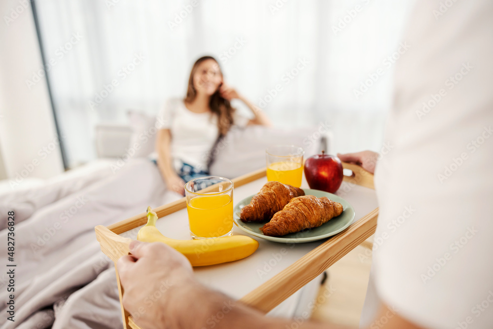 A man bringing a healthy breakfast in bed for him and his wife. A man bringing a healthy breakfast in bed for him and his wife.