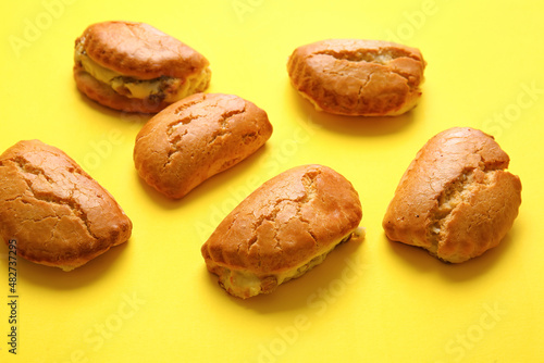 Tasty sochniki with cottage cheese on yellow background