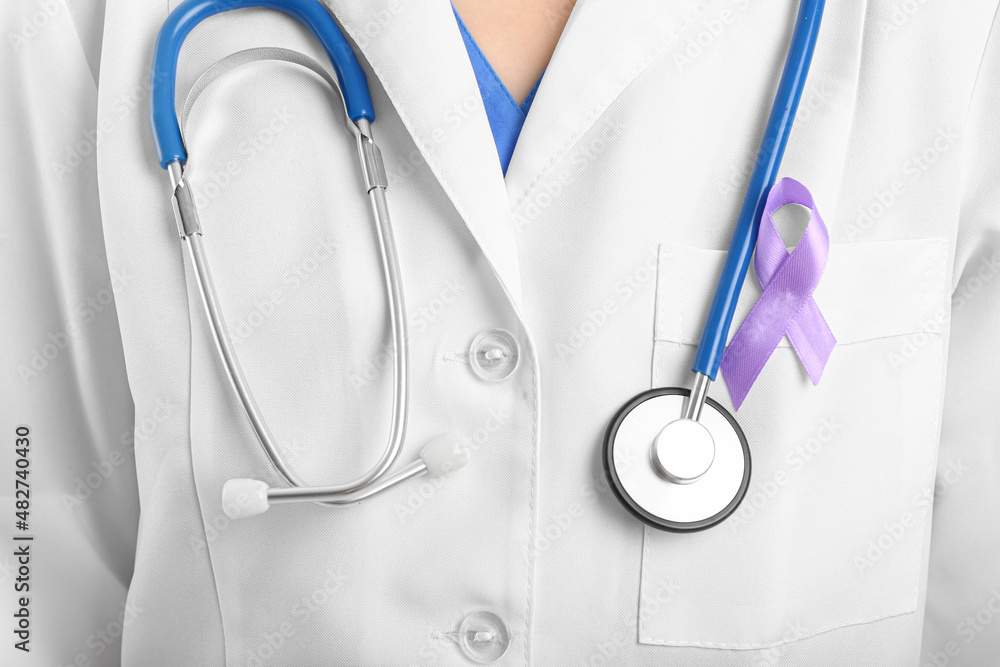 Female doctor with lavender awareness ribbon, closeup. World Cancer Day Female doctor with lavender awareness ribbon, closeup. World Cancer Day