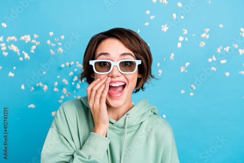 Photo of excited charming woman wear green sweatshirt sunglass flying popcorn laughing isolated blue color background