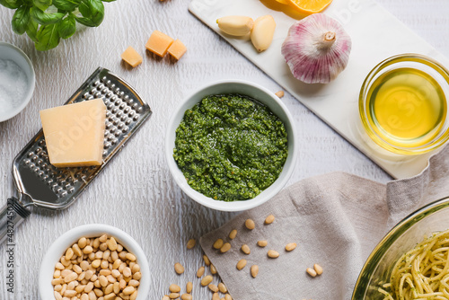 Tela Bowl of pesto sauce and ingredients on light background