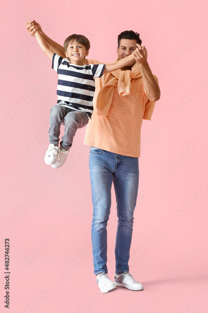 Happy man playing with his son on color background Happy man playing with his son on color background