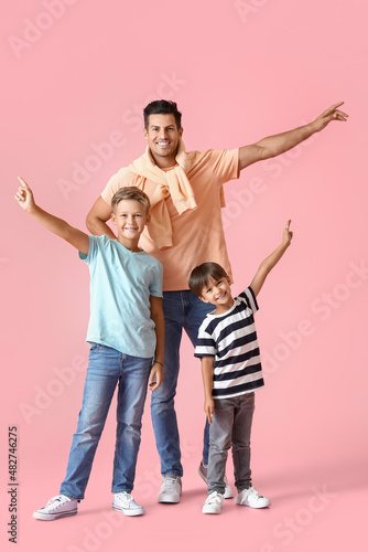 Happy man and his sons on color background