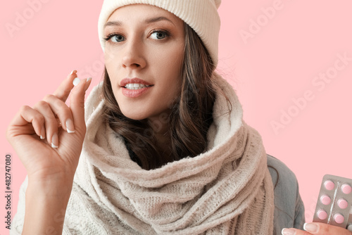 Young sick woman taking pil...