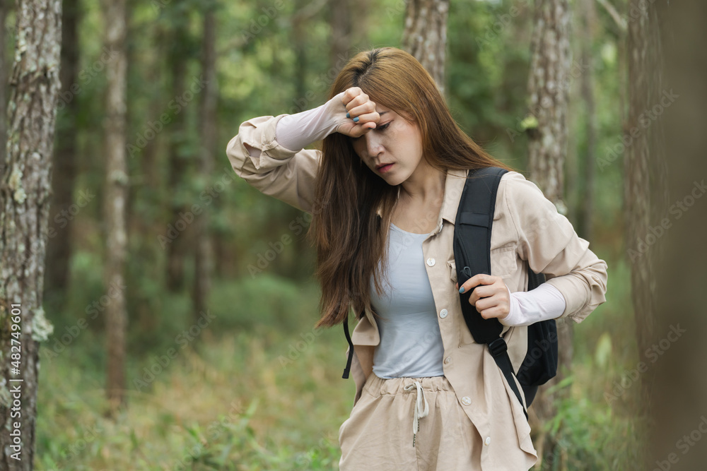 tired woman carrying a backpack travel and walking in forest tired woman carrying a backpack travel and walking in forest