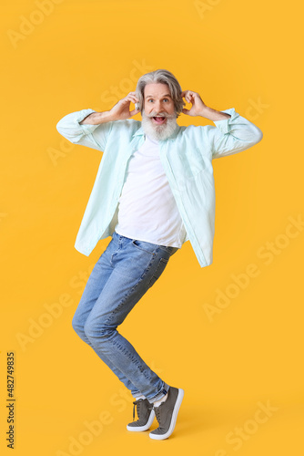 Happy senior man in headpho...