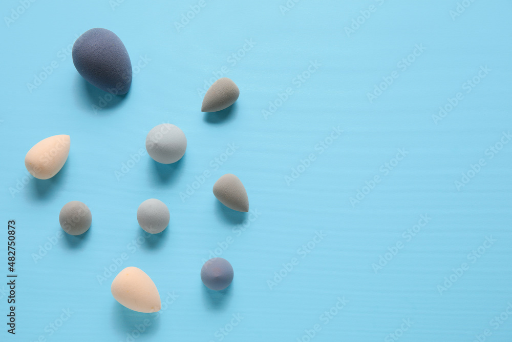 Different makeup sponges on blue background