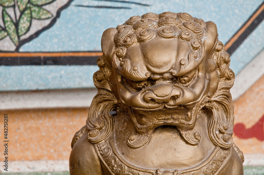 Strong and majestic golden dark bronze Asian Chinese lion metalic statue in a temple Strong and majestic golden dark bronze Asian Chinese lion metalic statue in a temple