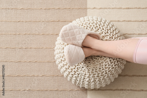 Woman resting on pouf at home, closeup photo