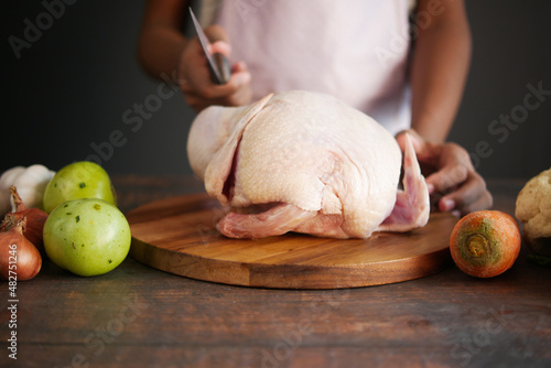  raw whole chicken and vegetables on tiles background  photo